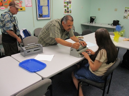 Mary learning more about the Perkins brailler in the Braille club